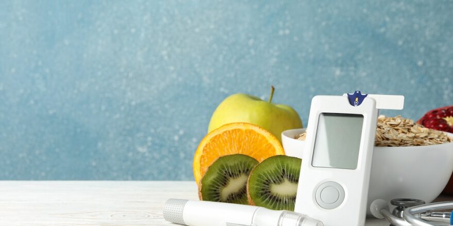 Blood glucose meter and diabetic food on wooden table