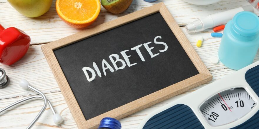 Word Diabetes and diabetic accessories on wooden background